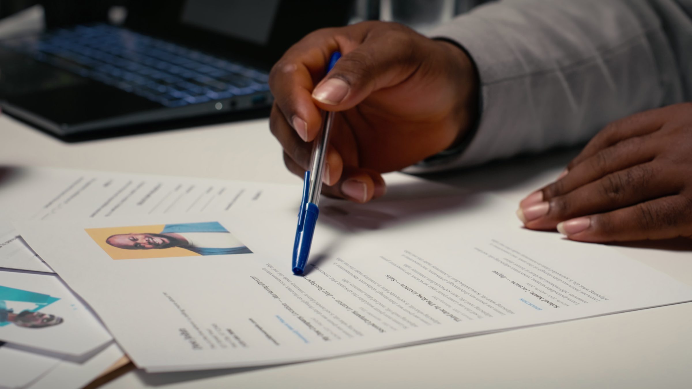 A recruiter reviewing a printed CV at a desk