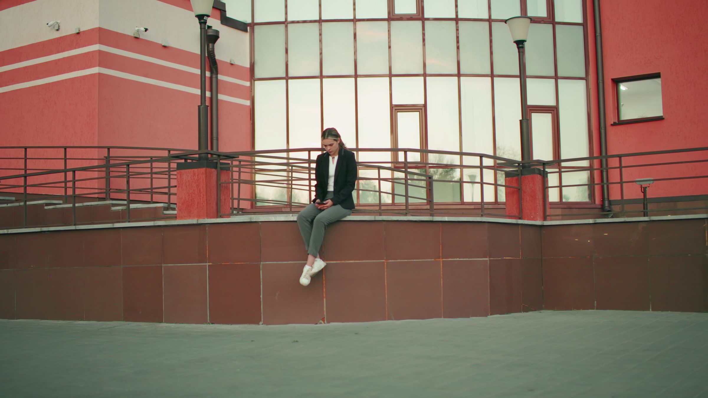 A young person waiting with a phone in hand